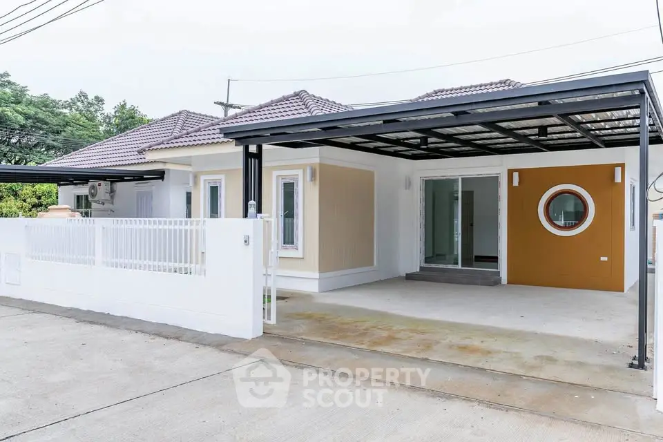Modern single-story house with carport and unique circular window design.