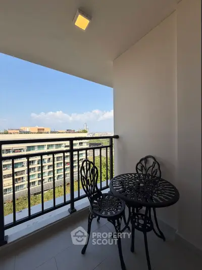Charming balcony with elegant wrought iron furniture and scenic city view, perfect for relaxation.