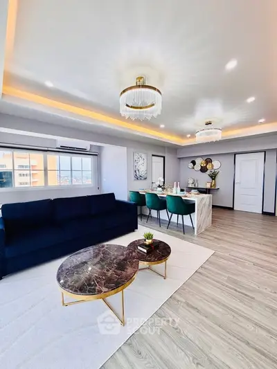 Luxurious open-plan living room with elegant chandeliers and modern dining area, perfect for entertaining.