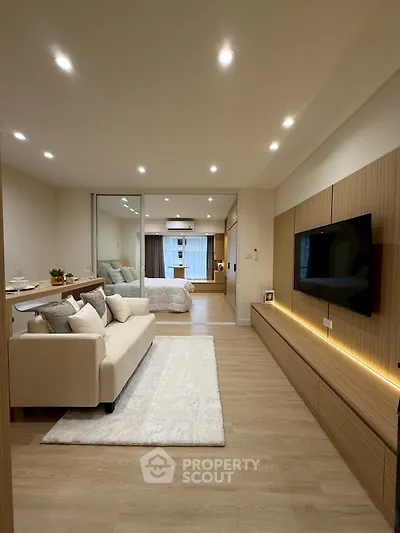 Modern open-plan living room with cozy seating and sleek wooden accents