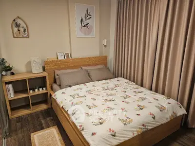 Cozy bedroom with floral bedding and wooden furniture, perfect for relaxation.