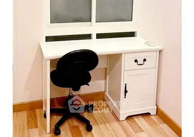 Cozy study nook with white desk and chair by a window, perfect for productivity.
