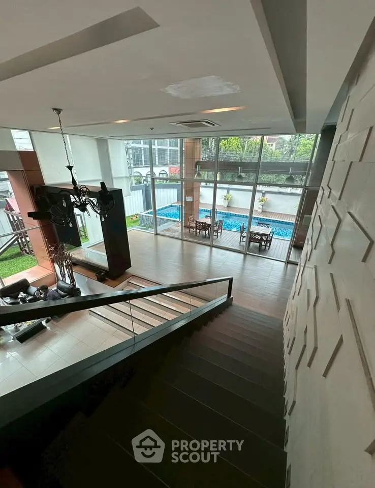 Luxurious modern living room with pool view and elegant staircase