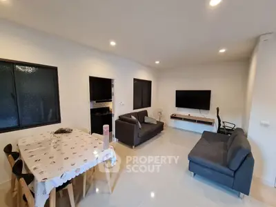 Modern living room with sleek furniture and dining area, perfect for family gatherings.