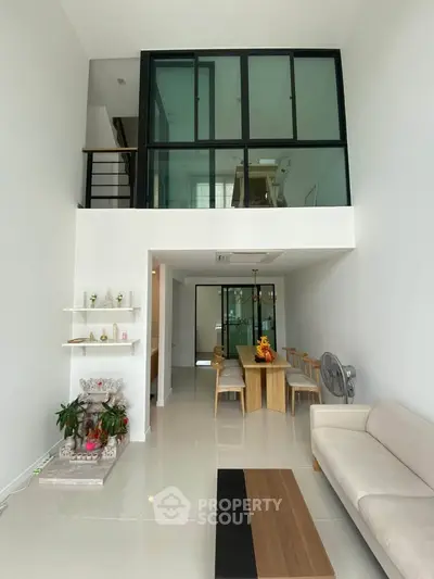 Modern duplex living room with high ceilings and elegant dining area