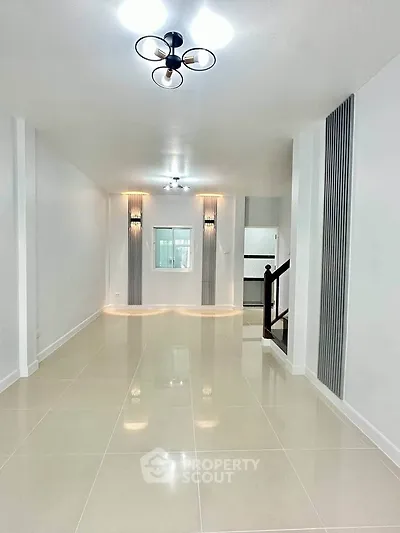 Spacious modern living room with elegant lighting and sleek tile flooring.