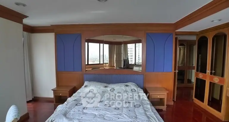 Spacious bedroom with wooden accents and large mirror, offering a cozy and inviting atmosphere.