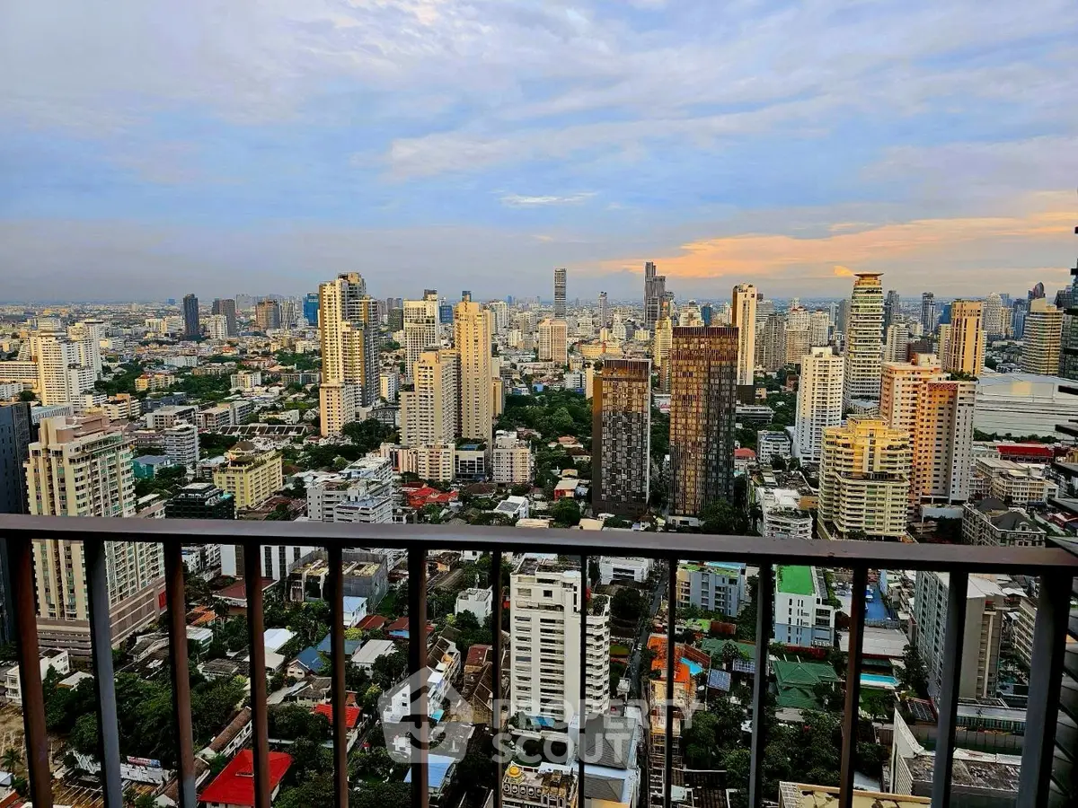 Stunning cityscape view from a high-rise balcony showcasing urban skyline at sunset.