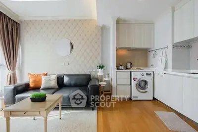 Modern living room with stylish decor and integrated kitchen featuring a washing machine.