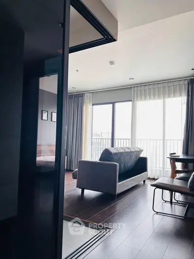 Modern living room with sleek furniture and large windows offering natural light.