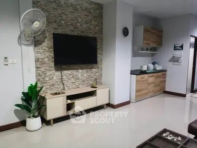 Modern living room with wall-mounted TV and stylish kitchen area