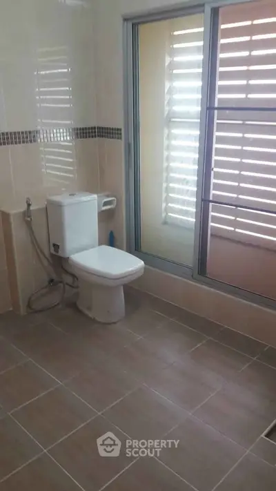 Spacious bathroom with modern fixtures and large window for natural light.