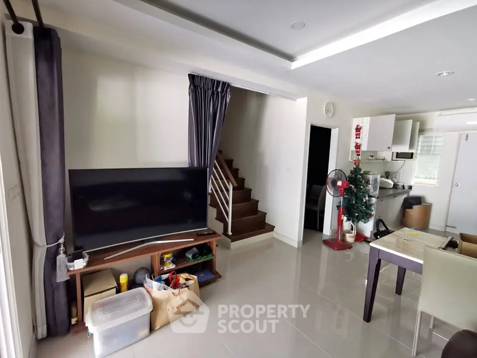 Spacious living room with modern decor and open kitchen layout, perfect for family gatherings.