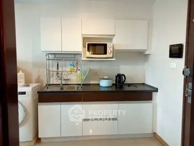 Modern kitchen with sleek cabinetry and appliances in a compact layout