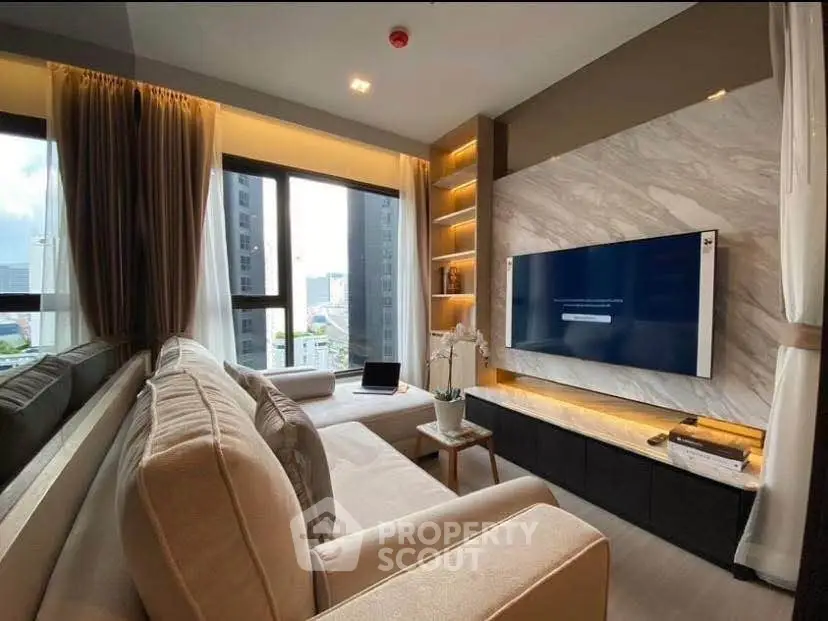 Luxurious modern living room with large windows and stylish decor in high-rise apartment.