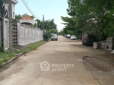Charming suburban street view with lush greenery and residential homes, perfect for peaceful living.