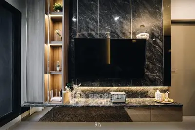 Luxurious living room with marble wall feature and mounted flat-screen TV, complemented by warm wooden accents and elegant decor.
