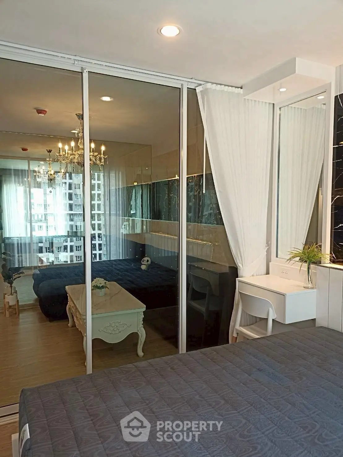 Luxurious bedroom with mirrored closet and elegant chandelier in modern apartment