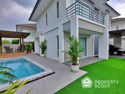 Modern two-story house with pool and lush green lawn, perfect for family living.