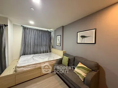 Modern bedroom with stylish decor and cozy sofa, perfect for relaxation.