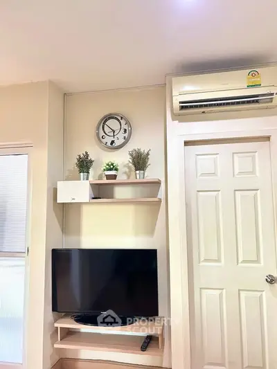 Modern living room with wall-mounted TV, air conditioning, and stylish decor