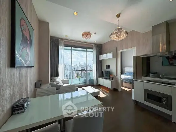 Modern open-layout living room with city view, elegant chandelier, and sleek kitchen appliances.