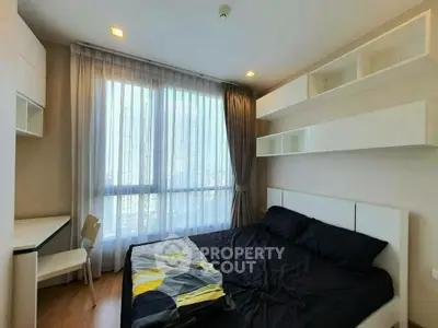 Modern bedroom with large window and stylish shelving in a contemporary apartment.