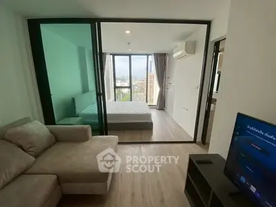 Modern apartment with glass partition, cozy living room, and city view from bedroom.