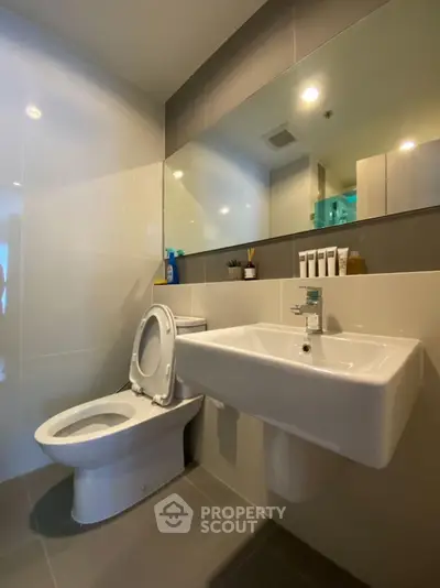 Modern bathroom with sleek fixtures and large mirror, perfect for a contemporary home.
