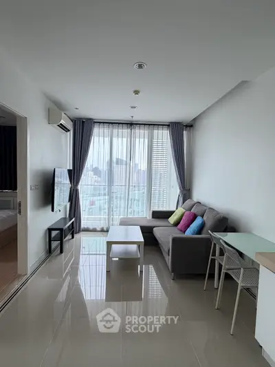 Modern living room with sleek furniture and large windows offering city views