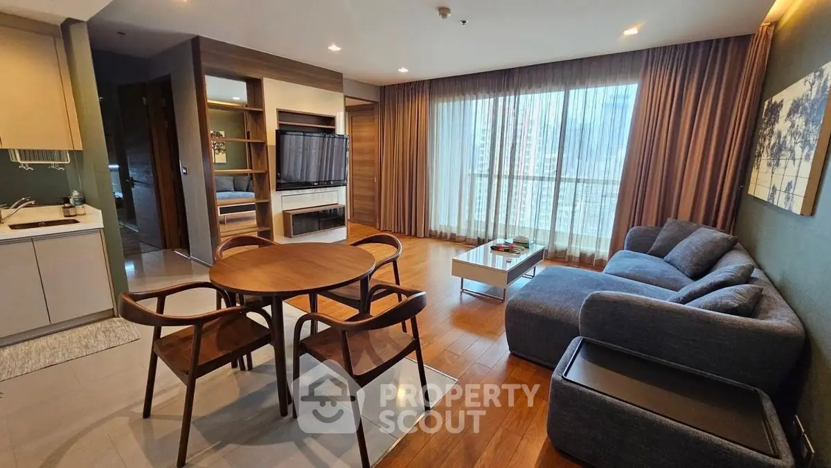 Spacious modern living room with large windows and stylish furniture in a high-rise apartment.