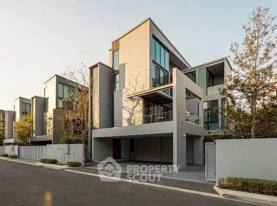 Modern multi-story building with sleek design and large windows in a serene neighborhood.