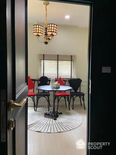 Charming dining area with unique chairs and elegant chandelier, perfect for cozy meals.