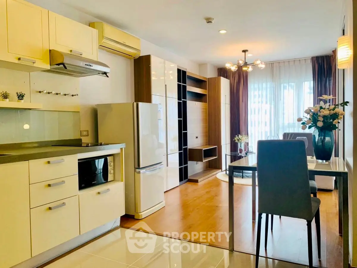 Modern open-layout kitchen and living room with stylish decor and natural light.