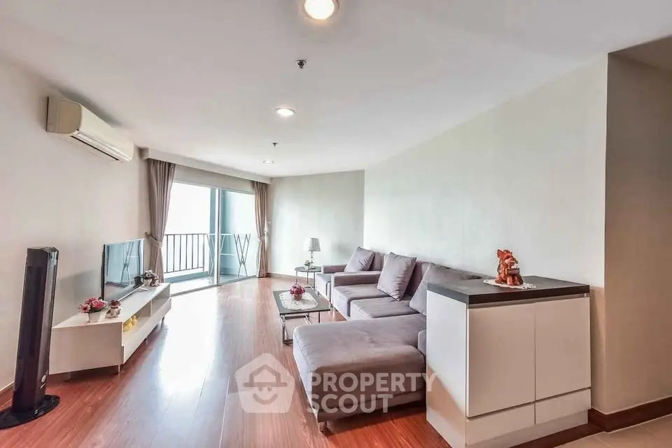 Spacious living room with modern decor and balcony access in a stylish apartment.