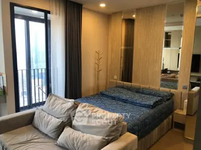 Modern bedroom with cozy sofa and large window offering city view