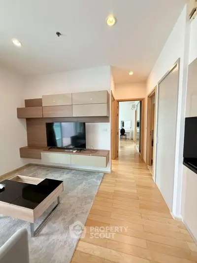 Modern living room with sleek wooden flooring and stylish TV unit