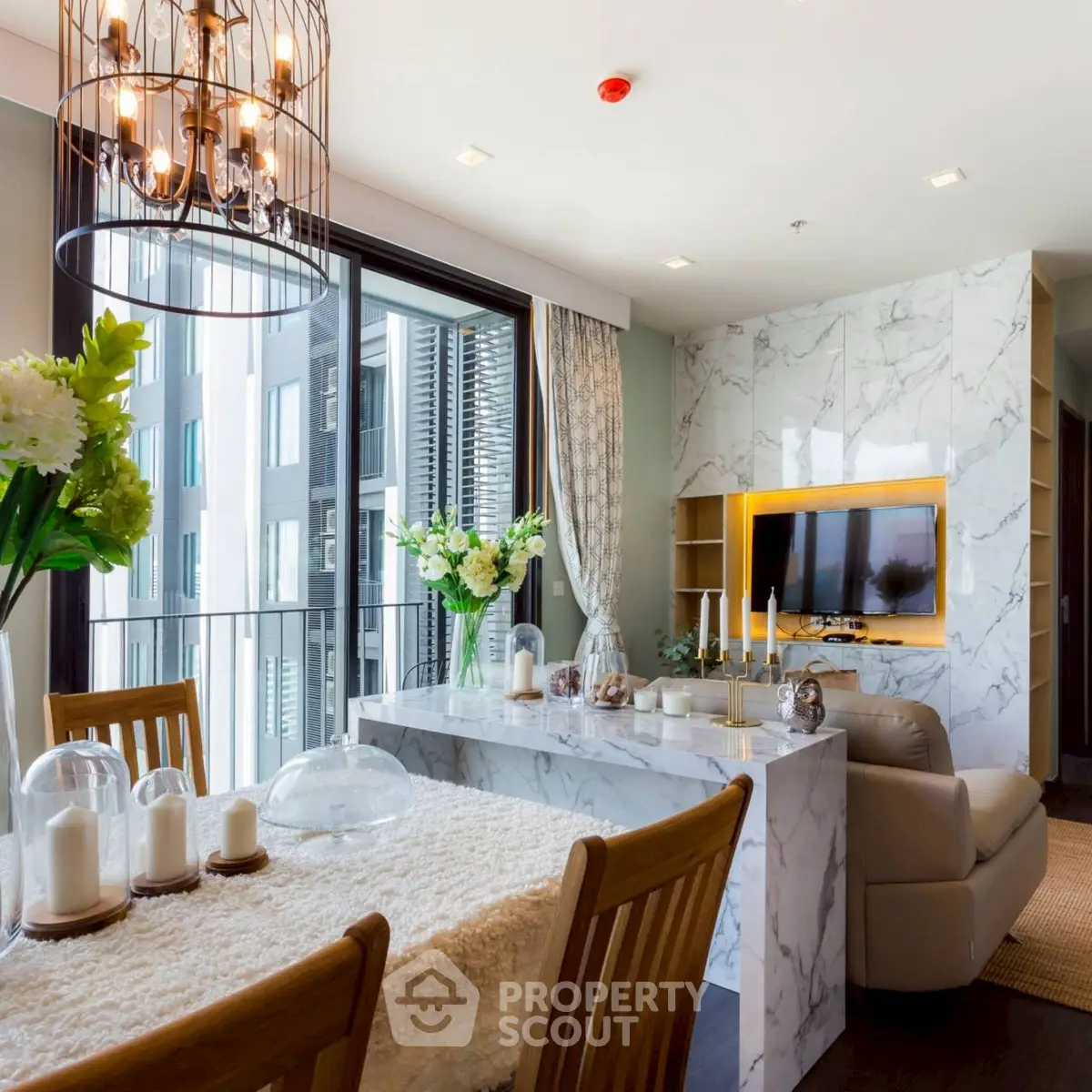 Luxurious living room with marble accents and elegant chandelier in modern apartment.