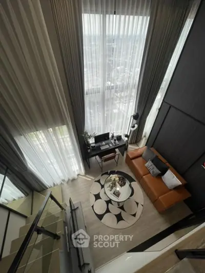 Modern loft with high ceilings and stylish decor, featuring a cozy living area and workspace.