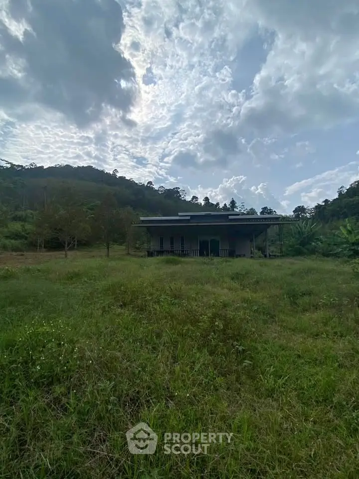 Charming rural property with lush greenery and scenic mountain backdrop.