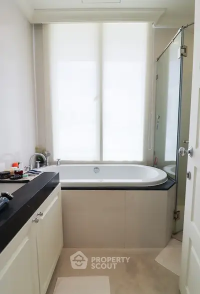 Modern bathroom with sleek bathtub and glass shower enclosure