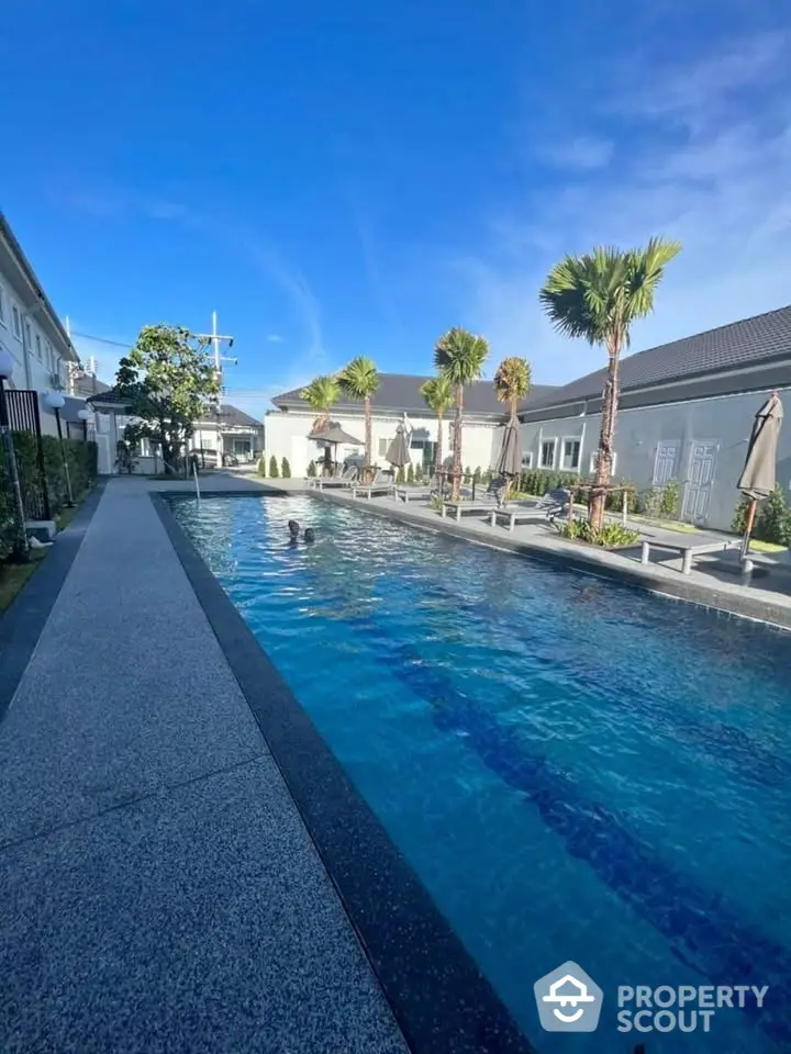 Luxurious outdoor swimming pool with palm trees and modern architecture