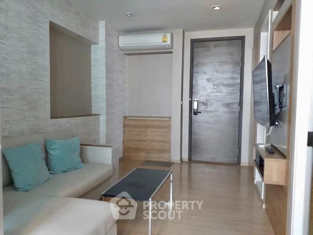 Modern living room with sleek design, featuring a wall-mounted TV and comfortable seating.