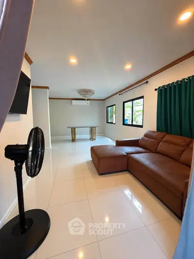 Spacious living room with modern brown leather sofa and elegant decor