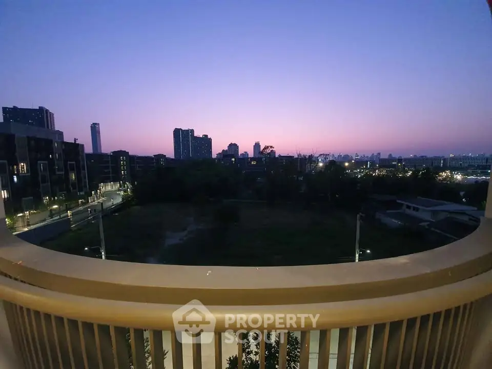 Stunning cityscape view from a balcony at dusk, showcasing urban skyline and serene ambiance.