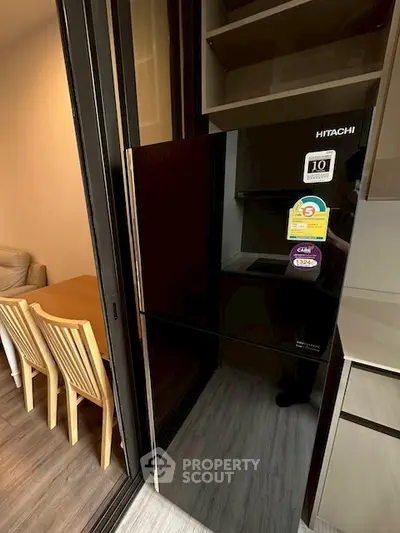 Modern kitchen with sleek black fridge and dining area