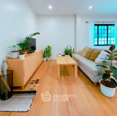 Charming living room with modern decor, wooden flooring, and abundant natural light.