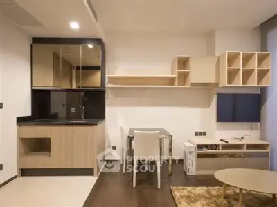 Modern minimalist kitchen with sleek cabinetry and dining area in stylish apartment.