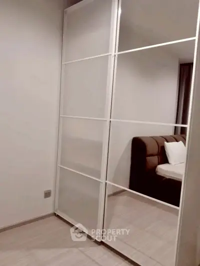 Modern bedroom with sleek sliding wardrobe and cozy bed setup