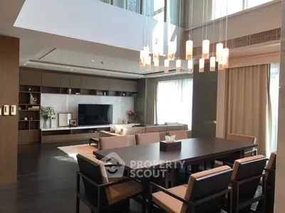 Luxurious modern living room with elegant dining area and stylish lighting fixtures.